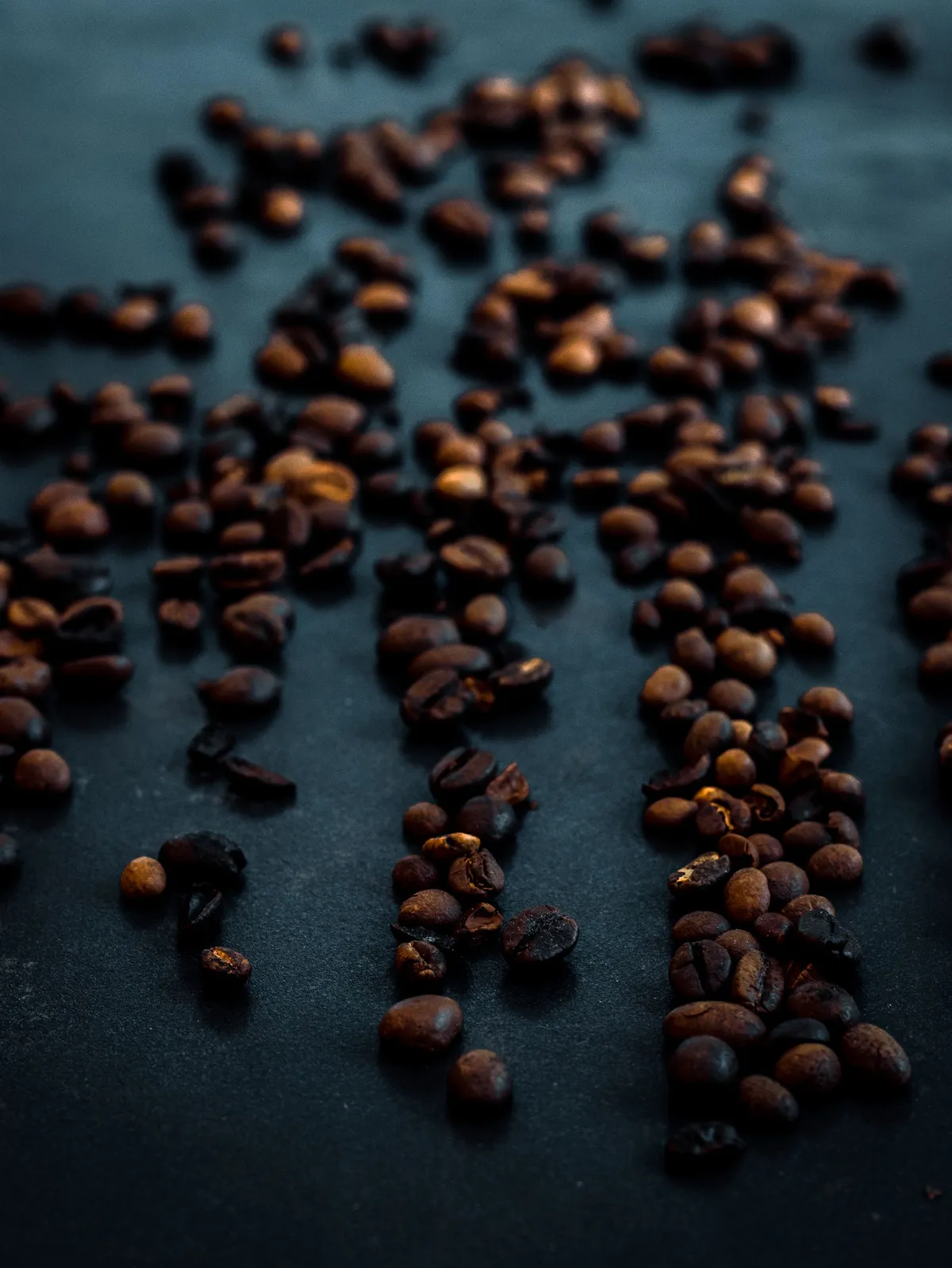 Granos de café tostados sobre una superficie oscura