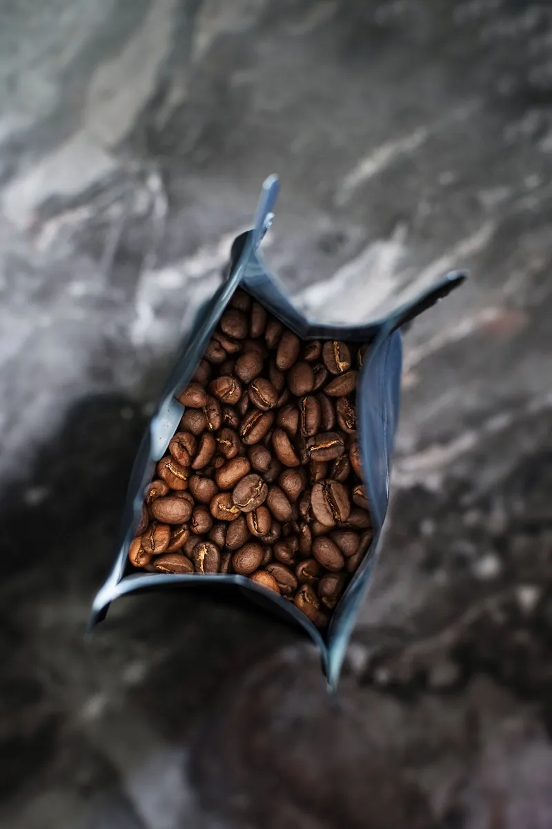 Vista cenital de granos de café en un paquete abierto