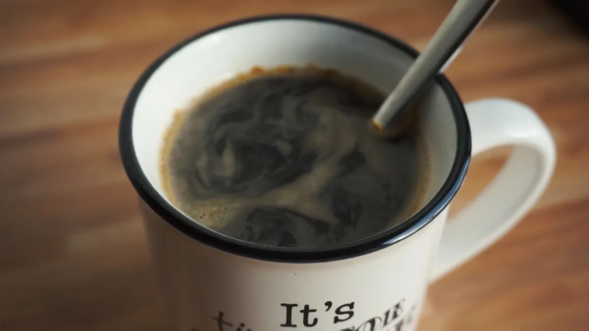 Taza de café solo negro humeante sobre la mesa